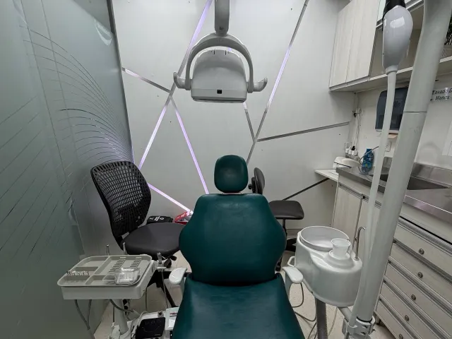 Consultorio del Dr. Julián Lopera en StarNova, con sillón verde y luces lineales en la pared