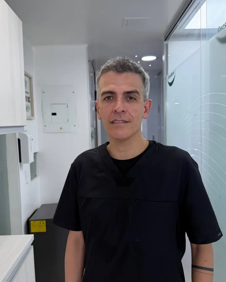 Retrato del Dr. Julián Lopera Ramírez con uniforme negro en el pasillo de StarNova
