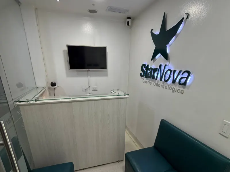 Sala de espera de StarNova Centro Odontológico con el logo iluminado en la pared